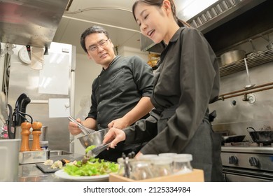 Male And Female Staff Serving Food At The Restaurant