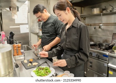 Male And Female Staff Serving Food At The Restaurant