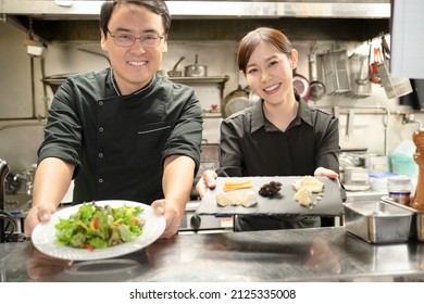 Male And Female Staff Serving Food At The Restaurant