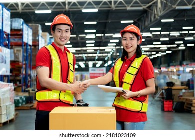 Male And Female Staff Workers Shaking Hands With Deals In Warehouse, Success Collaboration Concept, Teamwork.