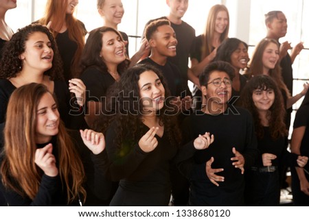 Male And Female Students Singing In Choir At Performing Arts School