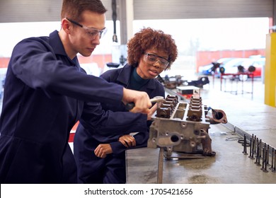 Male And Female Students Work On Car Engine Block On Auto Mechanic Apprenticeship Course At College