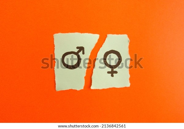 Male and female symbols drawn on torn paper note.\
Gender gap, inequality\
concept