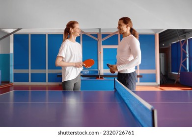 Male and female table tennis player taking break in ping pong practice - Powered by Shutterstock