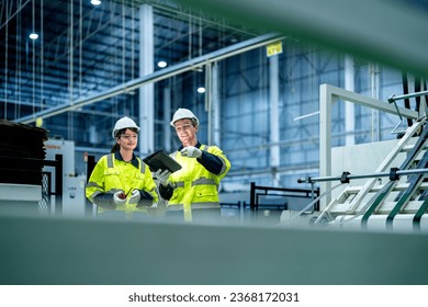 male and female technician engineers checking the process on Heavy machine. mechanical engineering team production. Industry manufacturing. Worker holding tablet and folde. High technology production. - Powered by Shutterstock