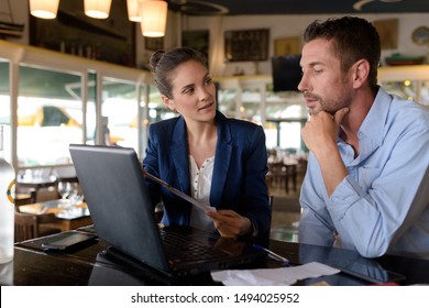männlich und weiblich mit einem Laptop in einem Restaurant