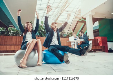 Male And Female Workers Exercising Stretching Arms In Office.