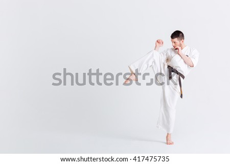 Male fighter in kimono posnig isolated on a white background