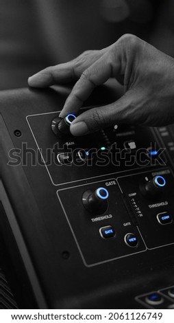 Male finger on audio mixer knob. Focus selected on the knob