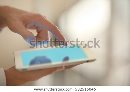 Male finger touching tablet screen on blurred background