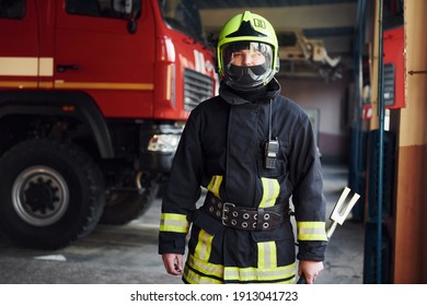 Male firefighter in protective uniform standing near truck. - Shutterstock ID 1913041723