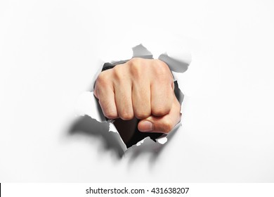 Male fist punching through paper, isolated on white - Shutterstock ID 431638207