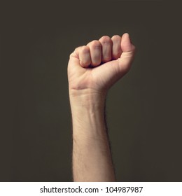 Male fist raised high in the air in a low light environment. - Shutterstock ID 104987987