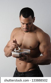 Male Fitness Model Eating Healthy Bodybuilding Diet Food Out Of Tupperware And Jug Of Water