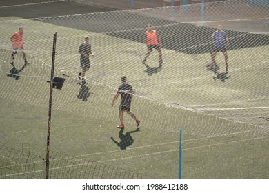 Male Football Player Training At A Sports Field. Soccer Player Avoids Incoming Slide Tackle During A Soccer Match.