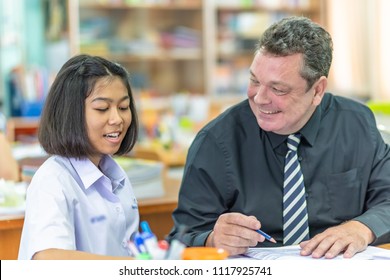 Male Foreign English Teacher Is Teaching Female High School Student In Thailand, Southeast Asian.