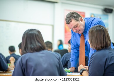 Male Foreign English Teacher Is Teaching High School Students In Classroom,  Thailand, Southeast Asian.