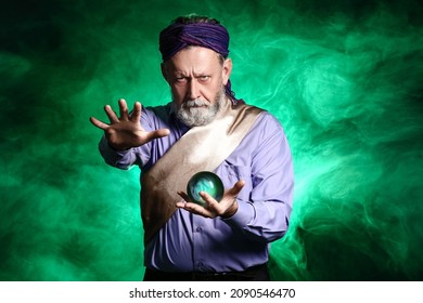 Male Fortune Teller With Crystal Ball On Dark Color Background