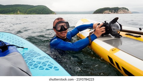 A Male Freediver In Blue Wetsuit With A Waterproof Camera On The Surface Of The Sea Preparing For The Next Dive. Extreme Sport.