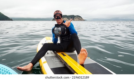 A Male Freediver In Blue Wetsuit With A Waterproof Camera On The Surface Of The Sea Preparing For The Next Dive. Extreme Sport.