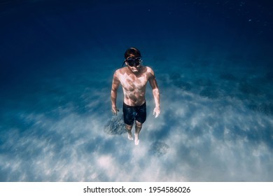 Male Freediver Glides Underwater In Blue Ocean In Hawaii.