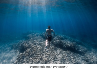 Male Freediver Glides Without Fins Underwater In Blue Sea