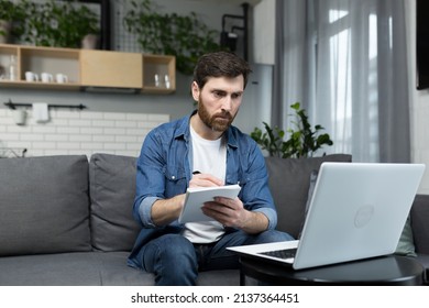 Male Freelancer Teaches Remotely, Uses Laptop, Looks At Webcam, Explains Economic Theory To Students