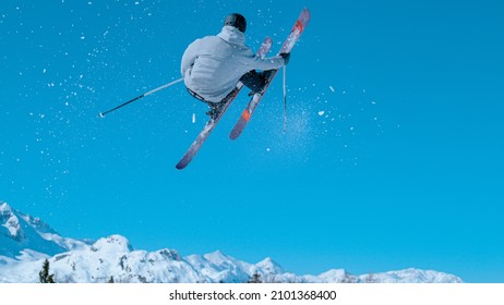 Male freestyle skier leaves a snow trail after taking off a kicker and doing a challenging 360 grab while riding in the snowpark of Vogel, Slovenia. Action shot of a man doing an extreme skiing trick.