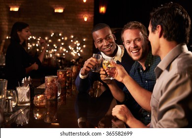 Male Friends Enjoying Night Out At Cocktail Bar - Powered by Shutterstock