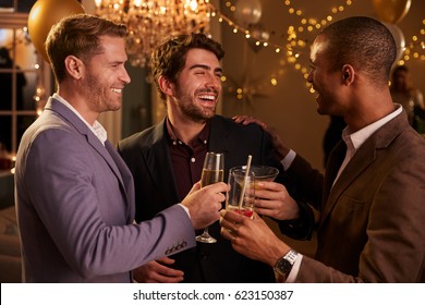 Male Friends Make Toast As They Celebrate At Party Together