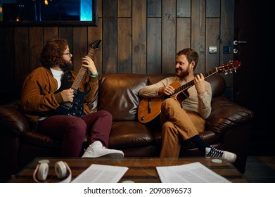 Male Friends Playing Guitar At Home Together