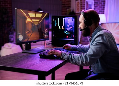 Male gamer focusing on online video games championship, playing action game on online live stream. Caucasian player having fun with virtual esport gameplay tournament on computer.