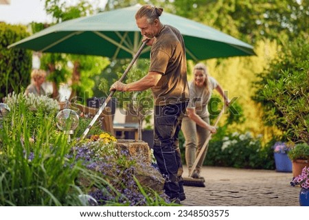 Similar – Image, Stock Photo Male gardener raking the the flower bed while the collegue is sweeping the terrace in summer