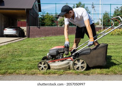 Male Gardener Unscrews The Plastic Fuel Tank Cap For A Gasoline Refueling Lawn Mower