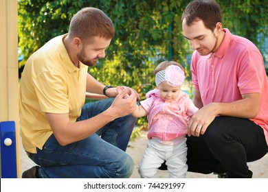 Male Gay Couple With Adopted Baby Girl, Outdoors