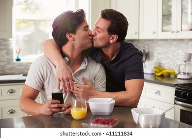 Male Gay Couple In Their 20s Kissing In Their Kitchen