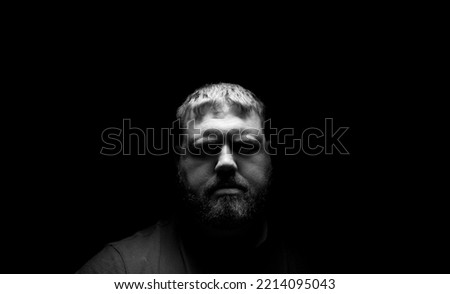 Male giving a blank expression in a dark enviroment. Stock fotó © 