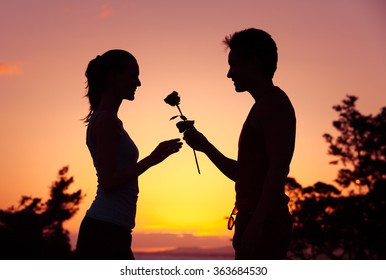 Male giving girl a rose. 