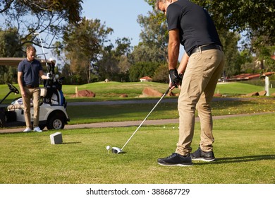 Male Golfer Lining Up Tee Shot On Golf Course