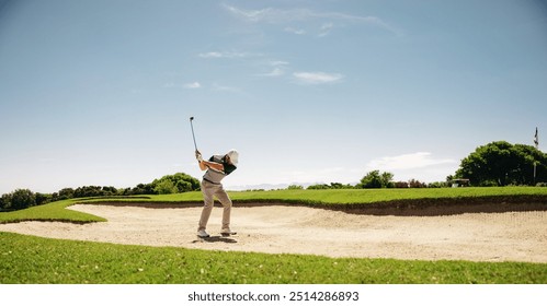 A male golfer skillfully swinging a golf club to escape a bunker during a competitive match, capturing determination and precision. - Powered by Shutterstock