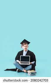 Male Graduating Student With Laptop On Color Background