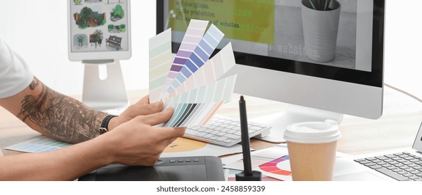 Male graphic designer choosing colors in office - Powered by Shutterstock