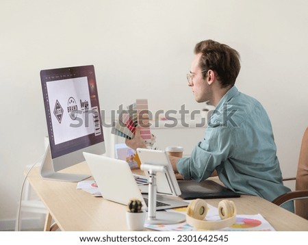 Male graphic designer developing logotype in office