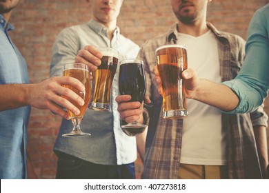 Male group clinking glasses of dark and light beer on brick wall background - Powered by Shutterstock