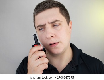 A Male Guard Talking On A Walkie-talkie With His Partner. A Policeman Takes Up The Challenge Of Public Safety. Safety And Security Concept