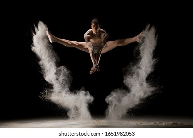 Male gymnast jumping in dust cloud view