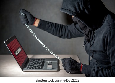 Male hacker locking computer using chain and lock, malware ransomware Trojan concept. Internet security concept