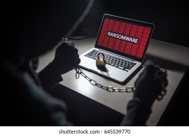 Male hacker locking computer using chain and lock, malware ransomware Trojan concept. Internet security concept