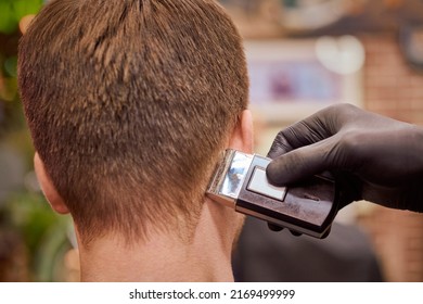 Male Haircut Shaving In Barbershop, Client Getting Haircut By Hairdresser With Electric Shaver. Hairdresser Makes Hairdo In Hairdresser Salon, New Stylish Modern Haircut For Man