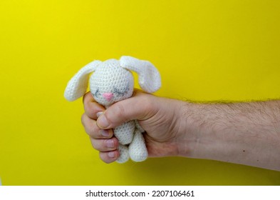 male hairy hand holding a toy on a yellow background, family photo, dad, father - Shutterstock ID 2207106461
